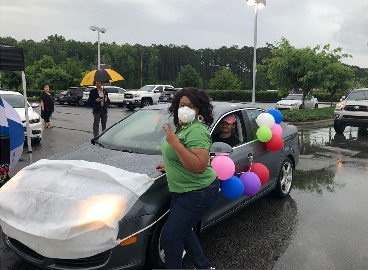 image of a woman posing in front of a car with balloons